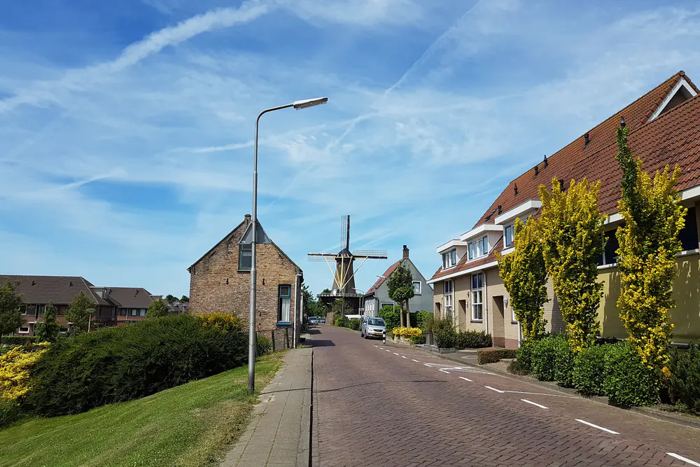 Straat in 's-Gravendeel met de molen op de achtergrond: vergelijk de rijscholen in 's-Gravendeel