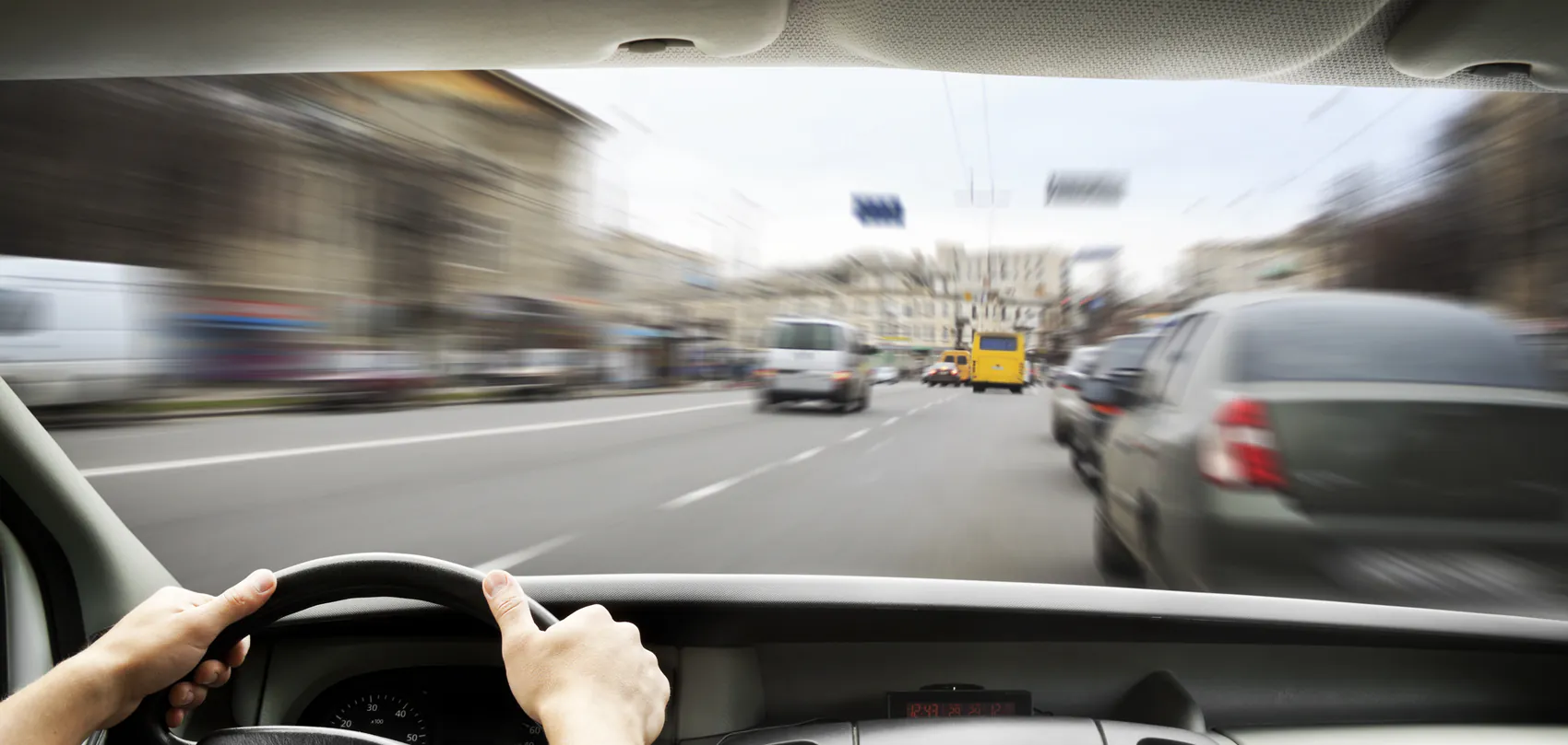 Zicht vanuit de cabine op het drukke stadsverkeer tijdens een rijles voor het vrachtwagenrijbewijs