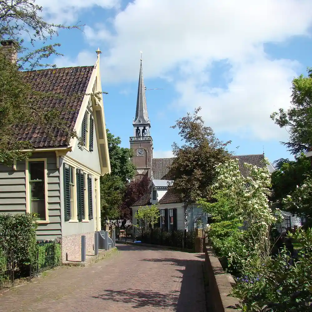 Een straat met de kerk in Broek in Waterland: vergelijk de rijscholen in Broek in Waterland