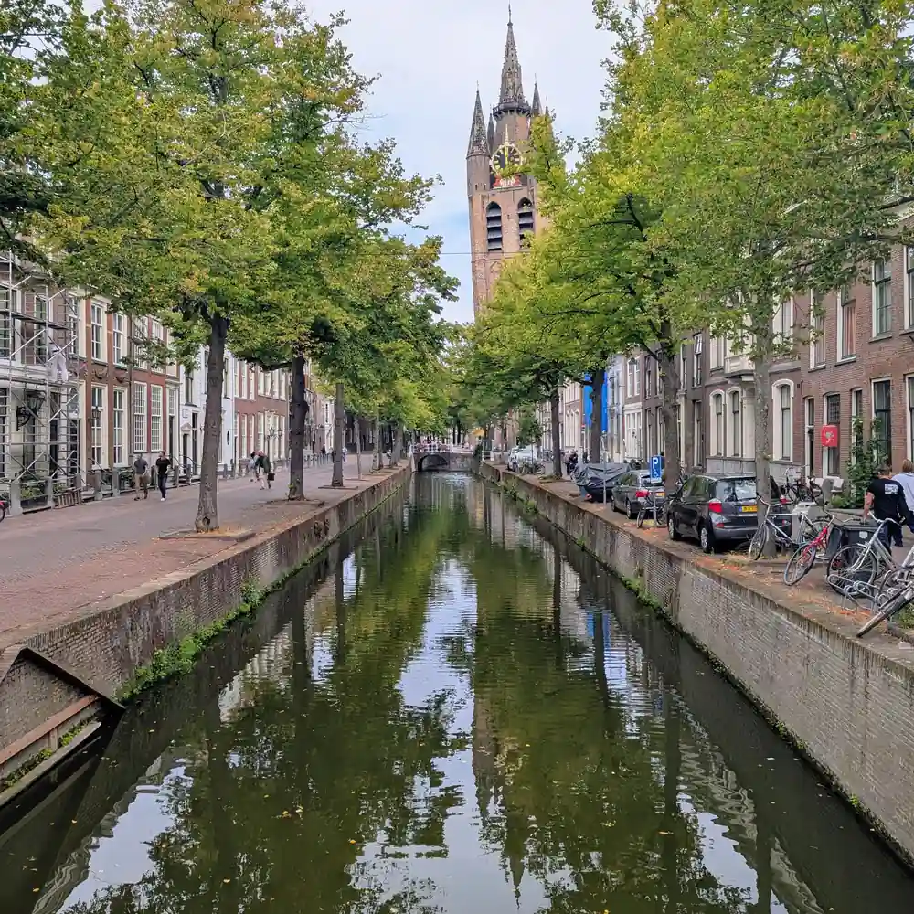 Een gracht met de Nieuwe Kerk in Delft, waar je de rijscholen in Delft kunt vergelijken