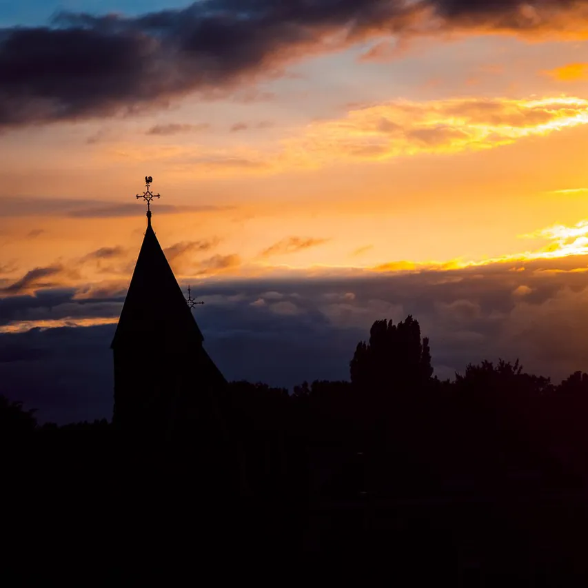 De kerktoren van Geldermalsen bij zonsondergang: vergelijk de rijscholen in Geldermalsen
