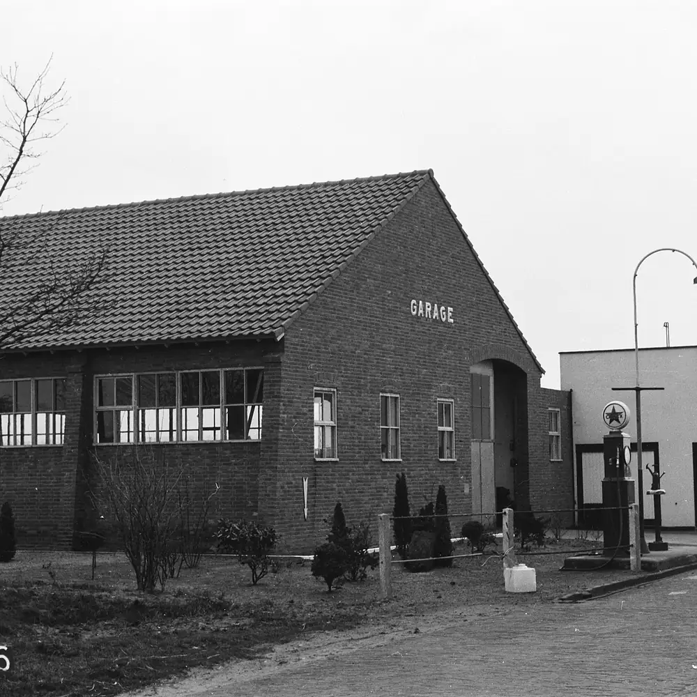 Een garage met benzinepomp in Goor op een oude foto: rijscholen in Goor vergelijken