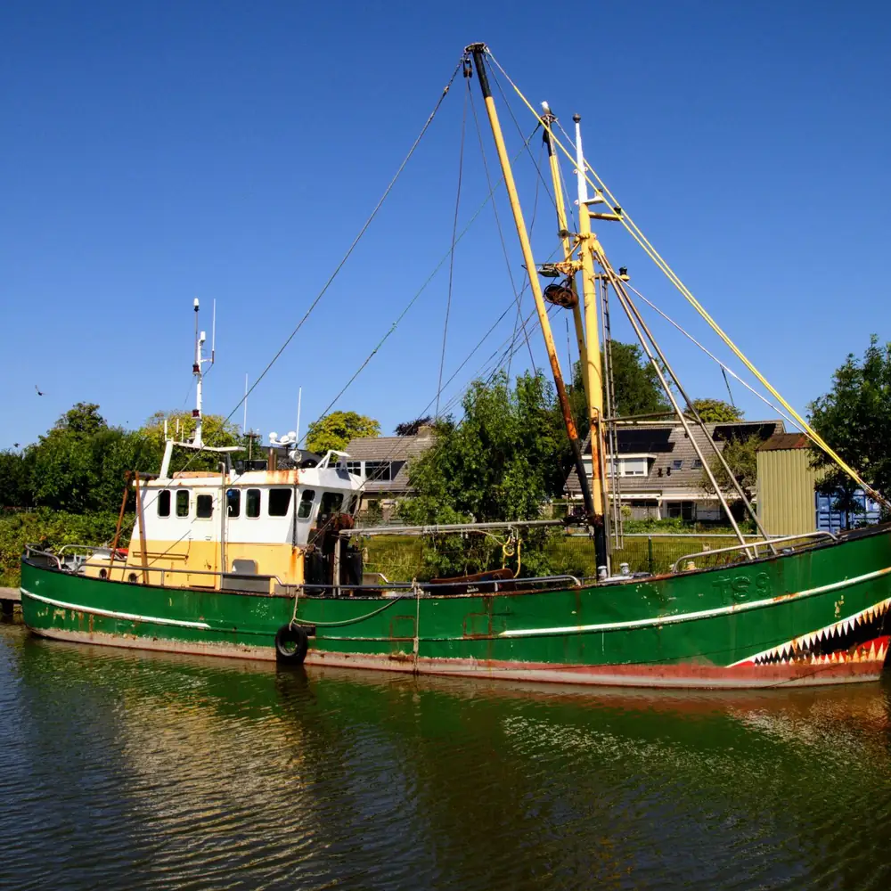 Een vissersboot in de haven van Harlingen: vergelijk de rijscholen in Harlingen