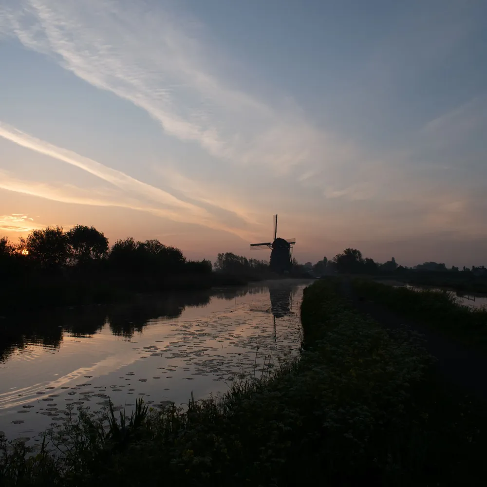 Een molen bij Hazerswoude-Dorp bij zonsondergang, waar je de rijscholen in Hazerswoude-Dorp kunt vergelijken