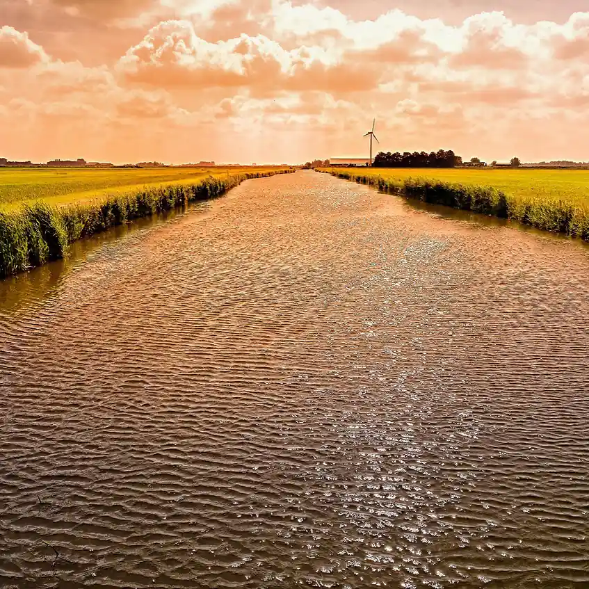 Een vaart met een molen bij Medemblik, waar je de rijscholen in Medemblik kunt vergelijken