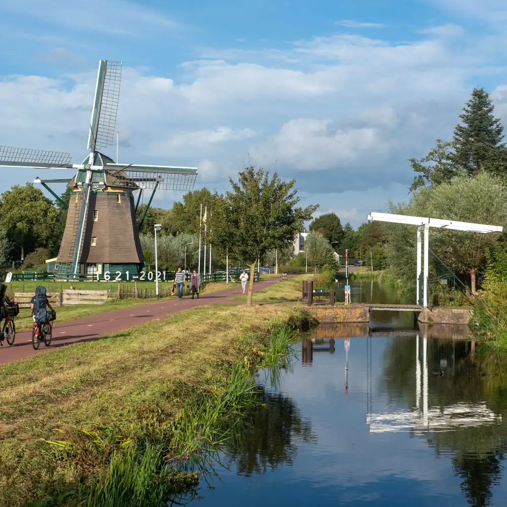 Fietsers langs een molen in Voorburg: rijscholen in Voorburg vergelijken